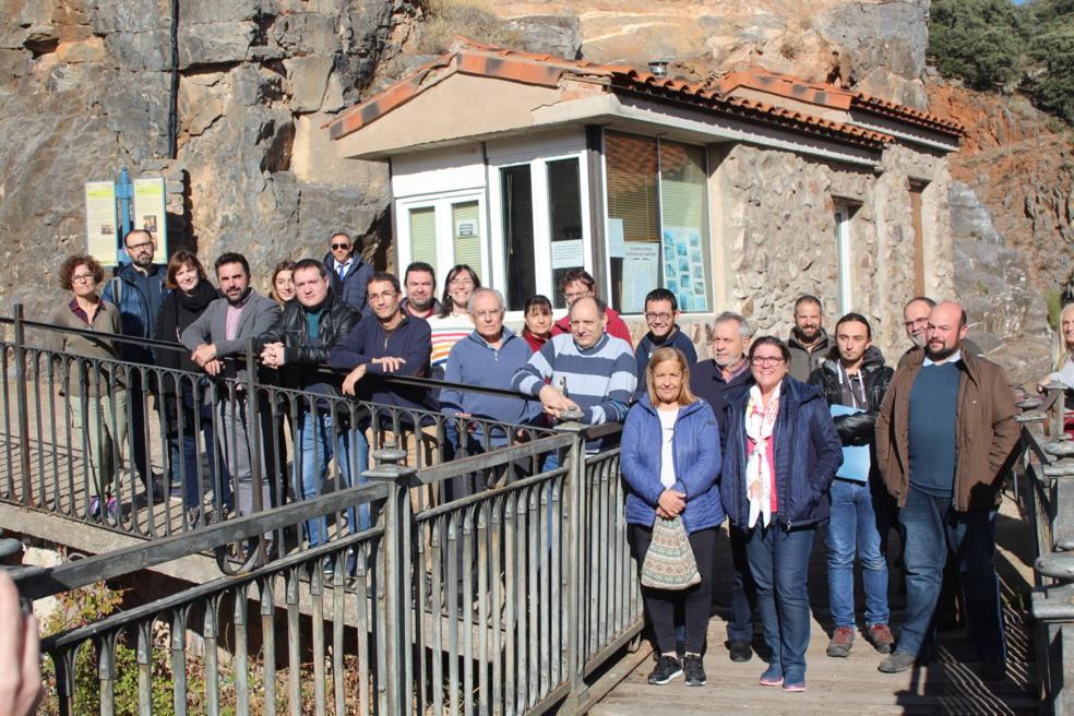 Autoridades, técnicos y vecinos posan en el acceso a las cuevas de Ortigosa de Cameros en la mañana de este viernes. 