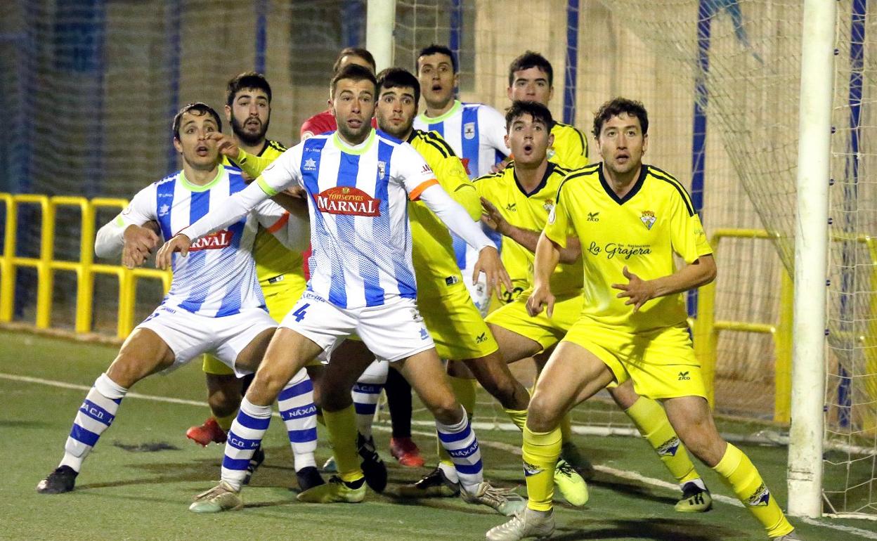 Los jugadores del Yagüe y del Náxara aguardan un centro. 