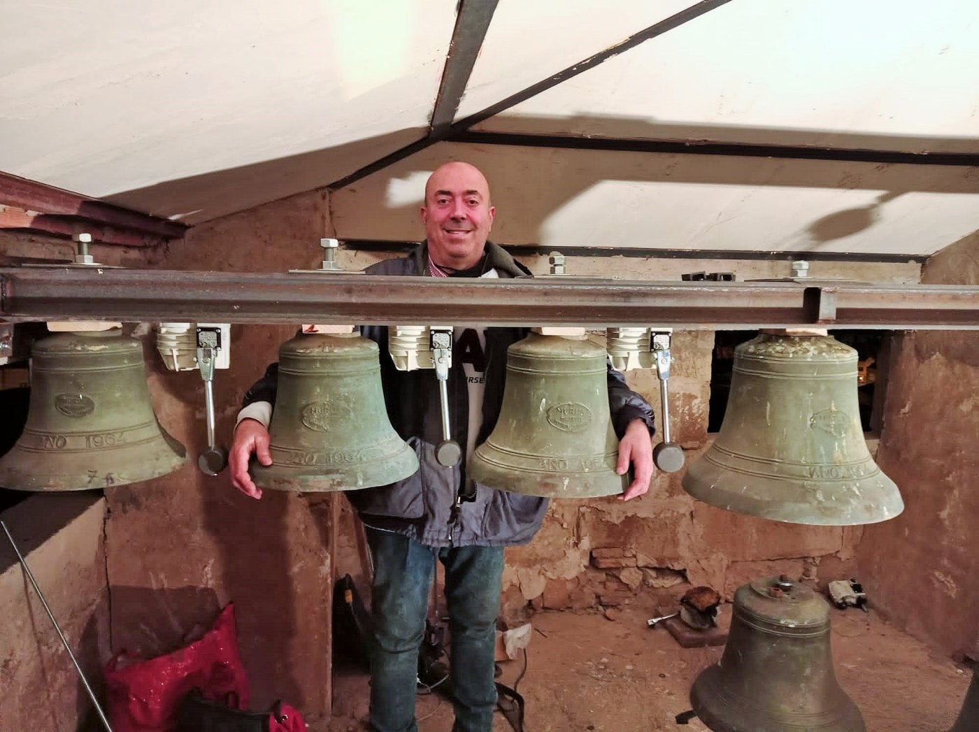 José Luis Tomás posa con las campanas donadas e instaladas en la iglesia de la Asunción de Villamediana