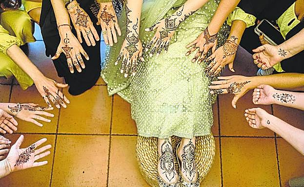 La novia y las invitadas muestran sus manos pintadas con henna en Viña Ijalba. 