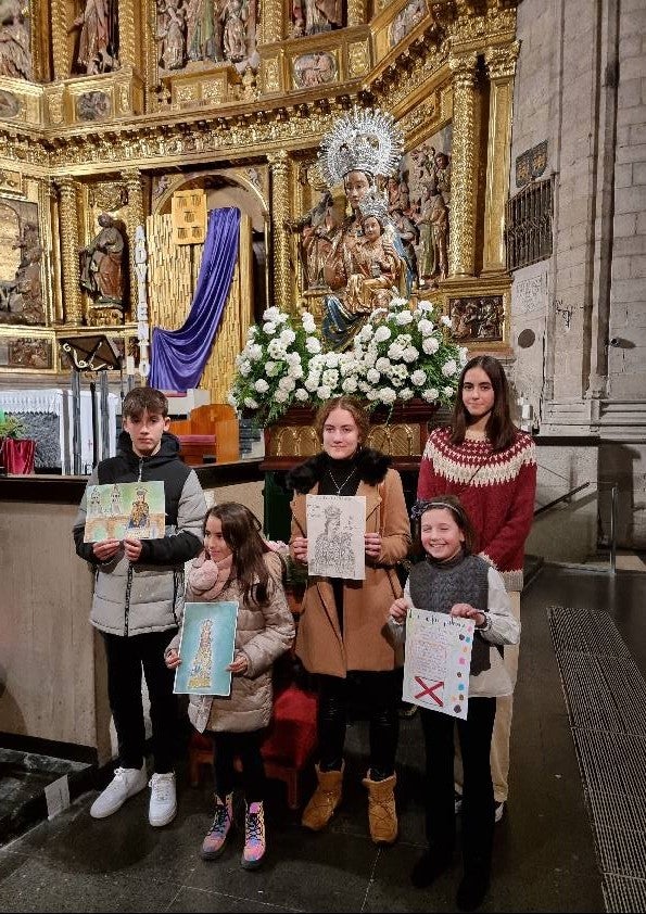 Imagen de los galardonados junto a la Virgen de la Esperanza en la iglesia de Santiago. 