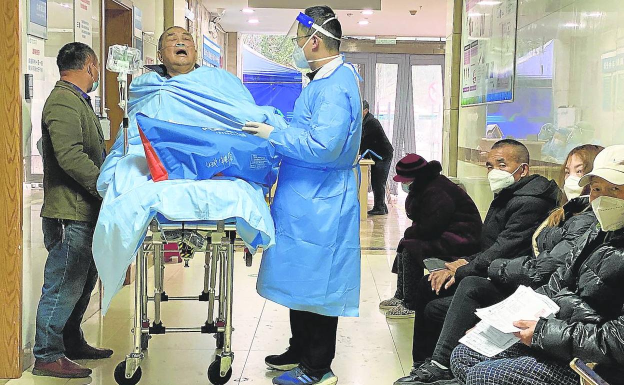 Un anciano con covid yace en una camilla en la sala de emergencias del hospital de Chongqing. 