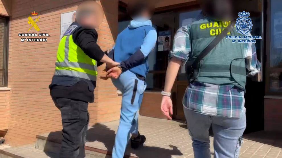 Agentes de Guardia Civil y Policía Nacional trasladan a uno de los detenidos.