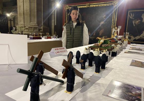 Una niña observa la procesión del Cristo Yacente. A la derecha, arriba, la Dolorosa con el nuevo palio y, abajo, visitantes en otro punto de la exposición.