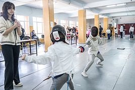 Una juez observa a los dos jóvenes tiradores.