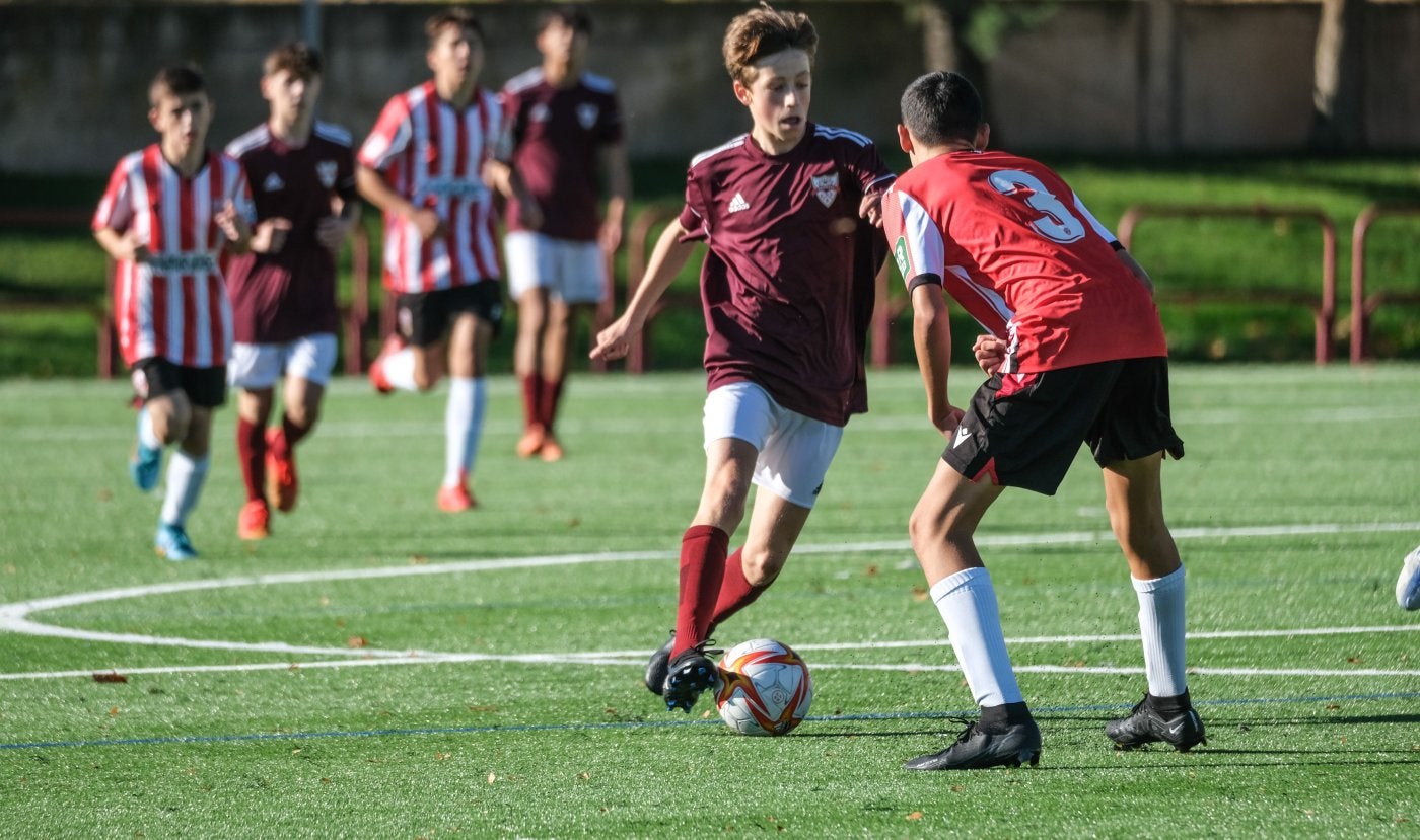 Un jugador de fútbol encara a un rival con intención de driblarlo.