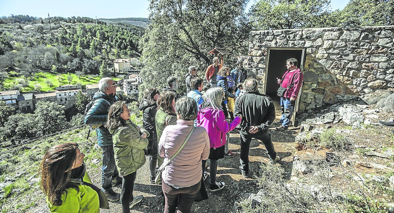 Un grupo de turistas atiende las explicaciones del guía Jorge Martínez antes de acceder a una de las grutas de Ortigosa