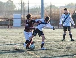 Un jugador del Valvanera protege el balón, acosado por un rival.