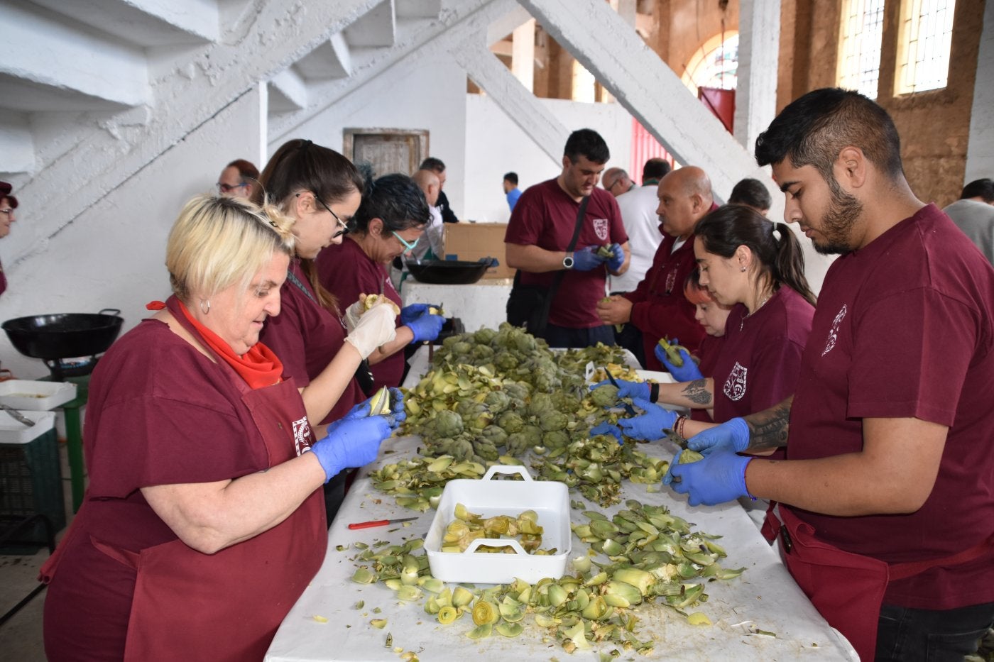 Peñistas de El Hambre preparando las alcachofas para su pincho.