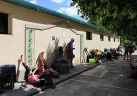 Algunos peregrinos descansan a las puertas del albergue municipal, a la espera de que abra para conseguir una plaza.