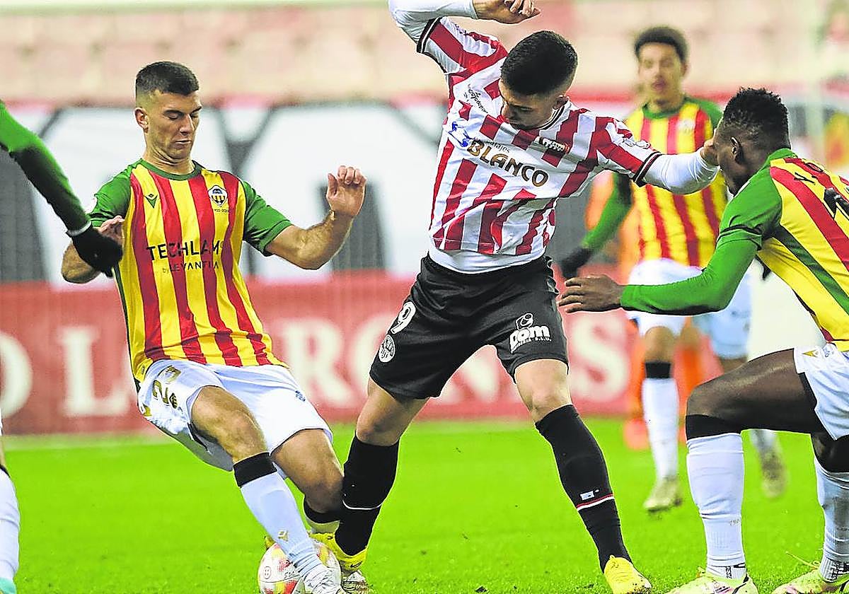 Unzueta trata de zafarse de dos adversarios del castellón en el partido de la primera vuelta.