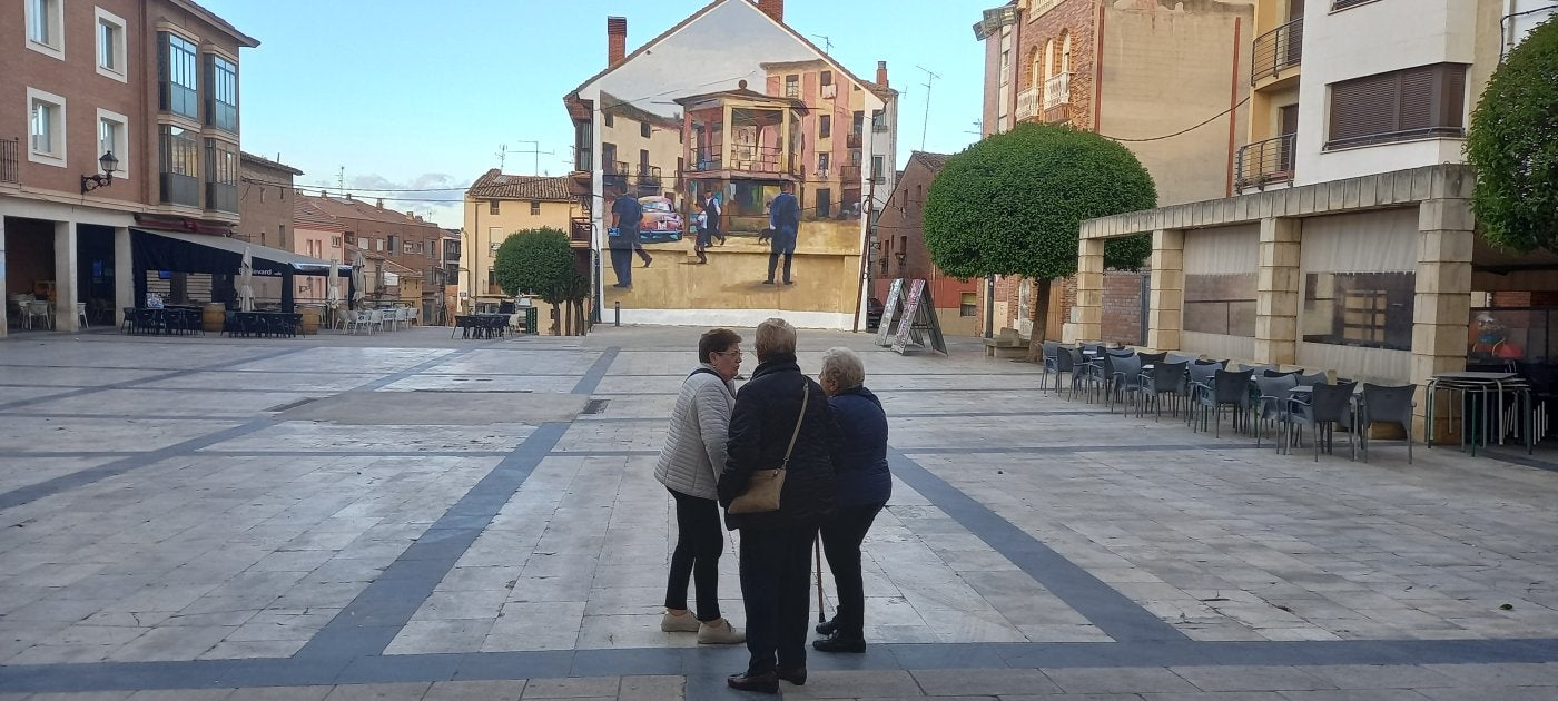 Unas mujeres observan el mural pintado por Martzel do Nascimento en la plaza de España de Lardero.