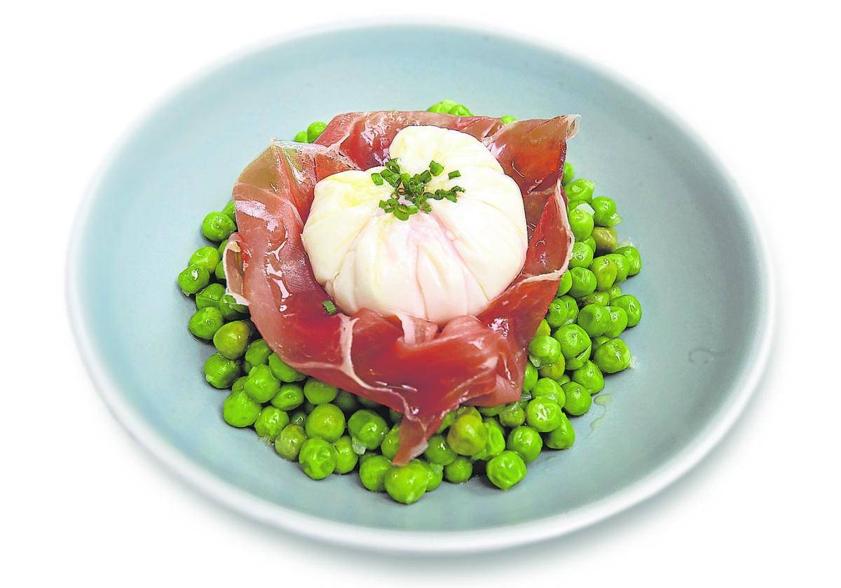 Guisantes con jamón y un huevo en flor.