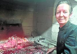 Dina Ugarte prepara unas chuletillas en la parrilla de su Asador El Buen Yantar, de Nájera.