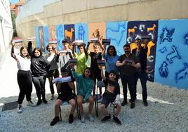 Alumnos y coordinadores del proyecto de innovación educativa posan con el teniente de alcalde en funciones, Enrique San Román, junto al mural 'Proyecto Rupestre' pintado en el centro.