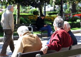 Pensionistas conversan en un banco de El Espolón de Logroño.