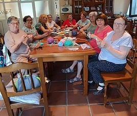 Las mujeres de San Millán trabajando en la confección de los banderines que adornarán el pueblo durante las fiestas de la Traslación.