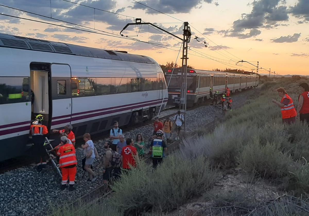 Pasajeros descendiendo del tren que ha quedado parado en la vía.