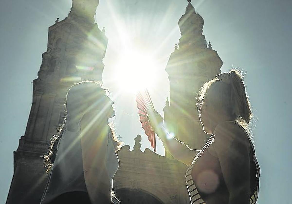 Dos jóvenes, al sol en la plaza del Mercado.