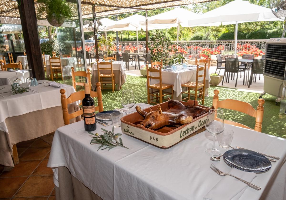 Una mesa, con el cochinillo recién asadado sobre ella, en la terraza de La Alameda.