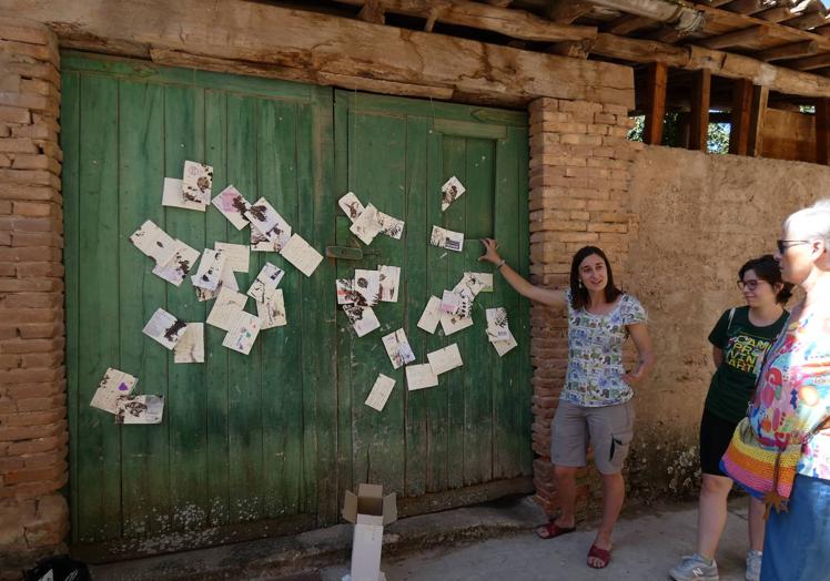 Imagen principal - Sofía Moreno explica su intervención basada en postales; Estela Ferrer, a la izquierda, con su obra 'Lavandera', y Ángel Peris enseñando las muestras de tierra que ha recogido