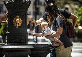 Un bebé se refresca en una fuente de Logroño.