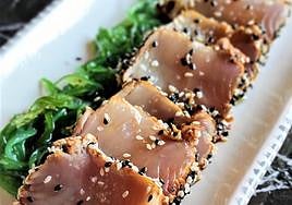 Una ración de bonito, con alga wakame y sésamo.