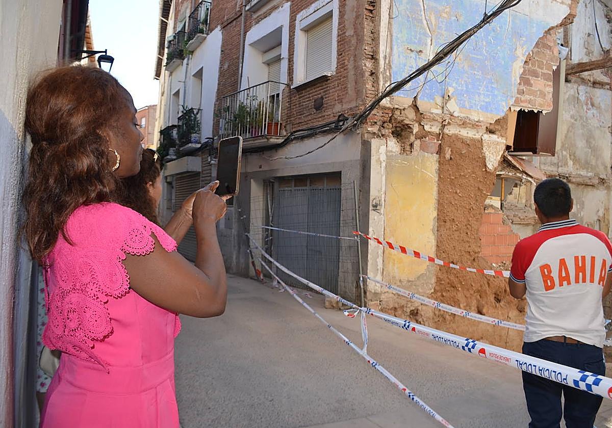 Vecinos afectados por el derrumbe observan los daños en la pared lateral del edificio de viviendas del número 18 de la calle San Andrés.