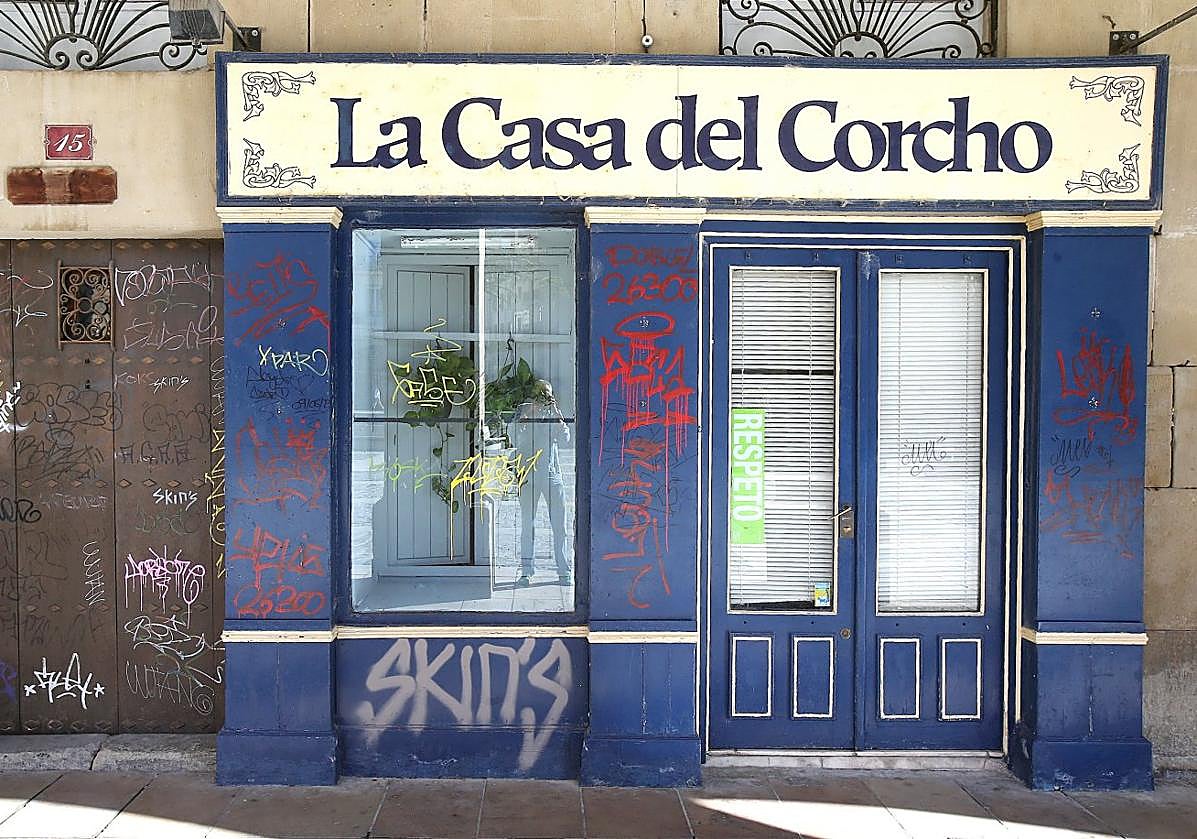 La Casa del Corcho, cerrada y grafiteada ya desde los primeros días pese a su histórico escaparate, junto a un portal repleto de firmas en la castigada plaza del Mercado.