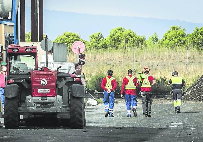 Operarios de las instalaciones esperan en el exterior del recinto.