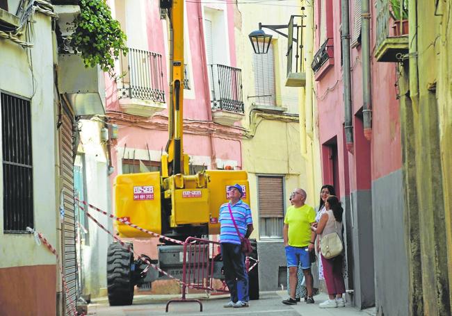 Varios vecinos observan el avance de las obras de derribo de la casa que se derrumbó en agosto en la calle San Andrés.