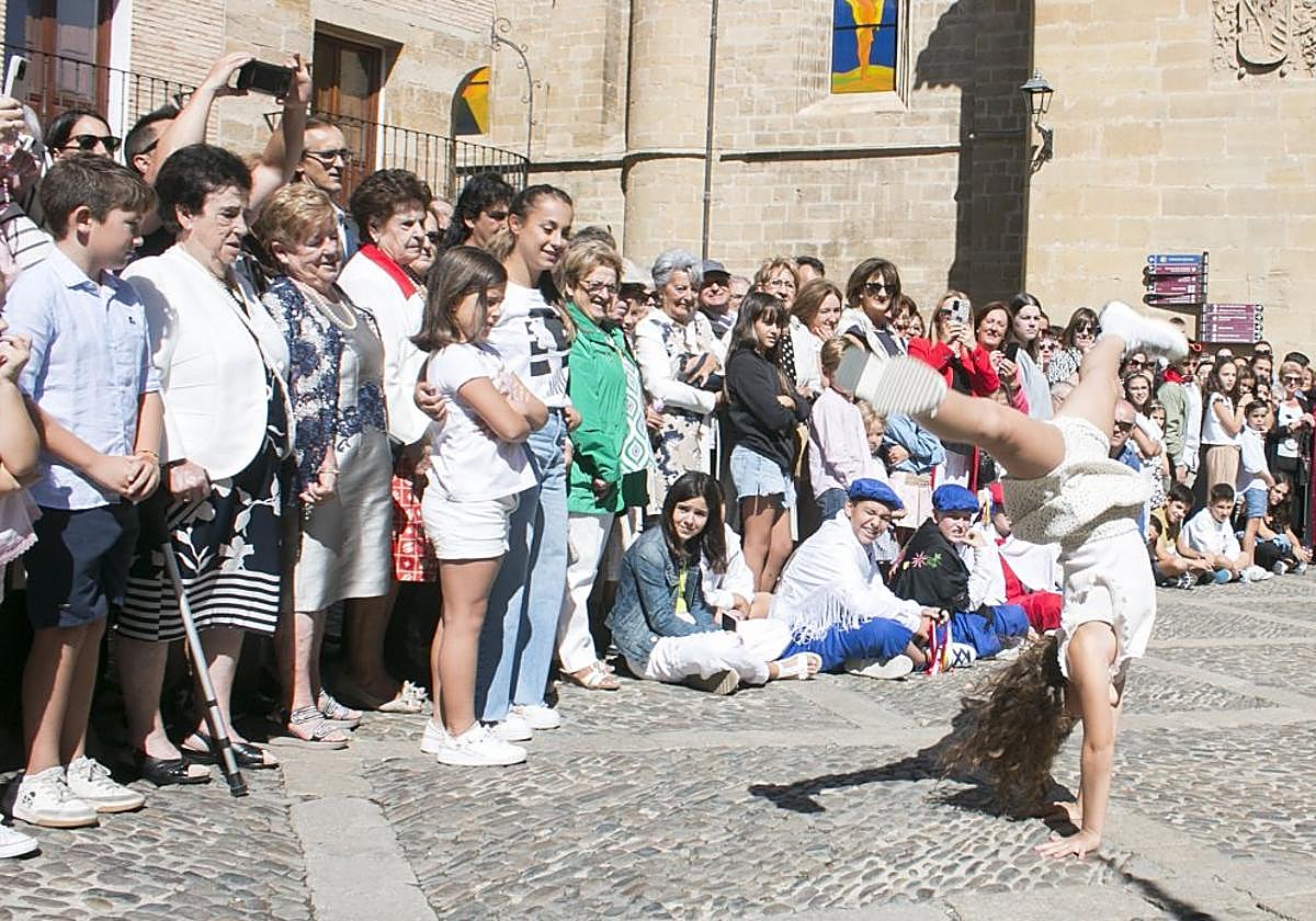 Una niña da los tradicionales volatines entre las imágenes de los patronos locales, Santo Domingo de la Calzada y la Virgen de la Plaza.