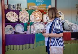 Una visitante de la feria observa el puesto de Tato Sheriff Studio (Portugal).