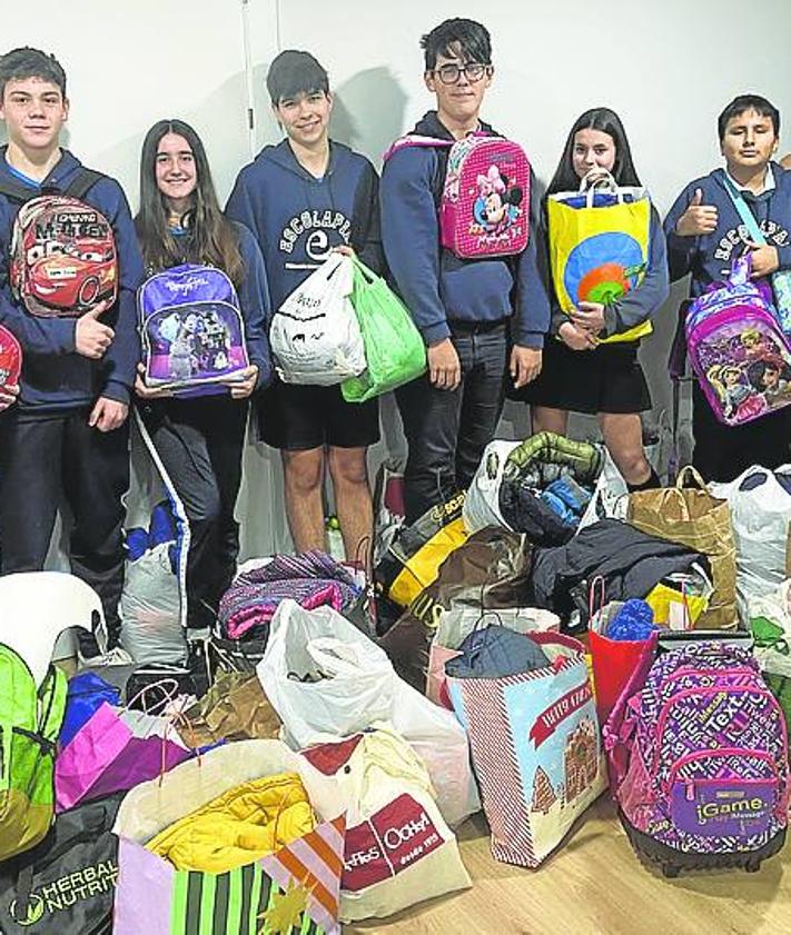 Imagen secundaria 2 - Alumnos, con la directora del colegio de Educación Especial de Dajla, Fatma Sidahmed, abriendo cajas con el material enviado y parte del material recogido en Escolapias Sotillo antes de ser embalado por los alumnos.