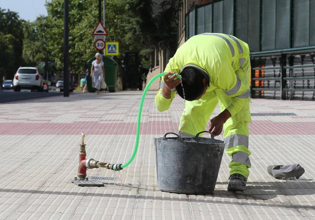 Un operario se refresca en las obras de Vara de Rey.