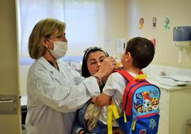 La enfermera Coral Arellano proporciona la vacuna intranasal a un niño en el consultorio de Villamediana.