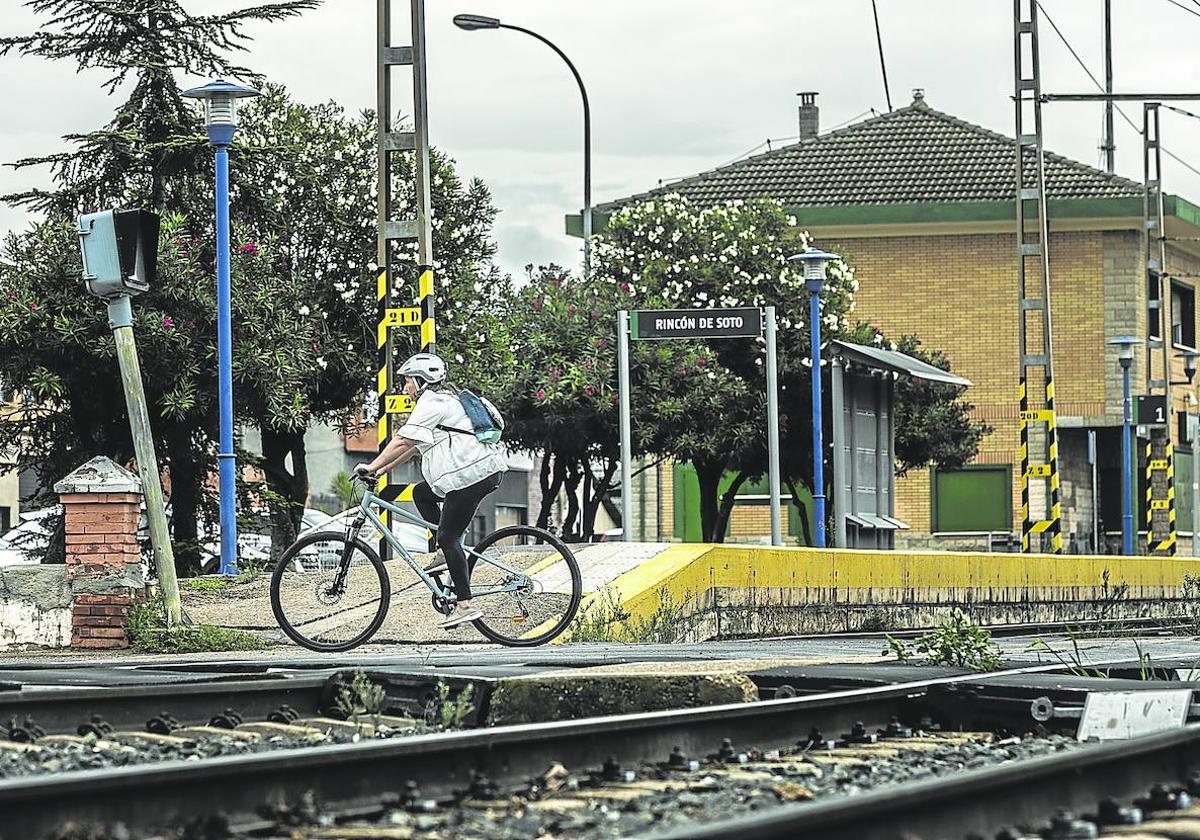 Una mujer cruza la vía del ferrocarril a su paso por Rincón de Soto en una de las zonas en las que todavía hay paso a nivel, junto a la estación de tren.