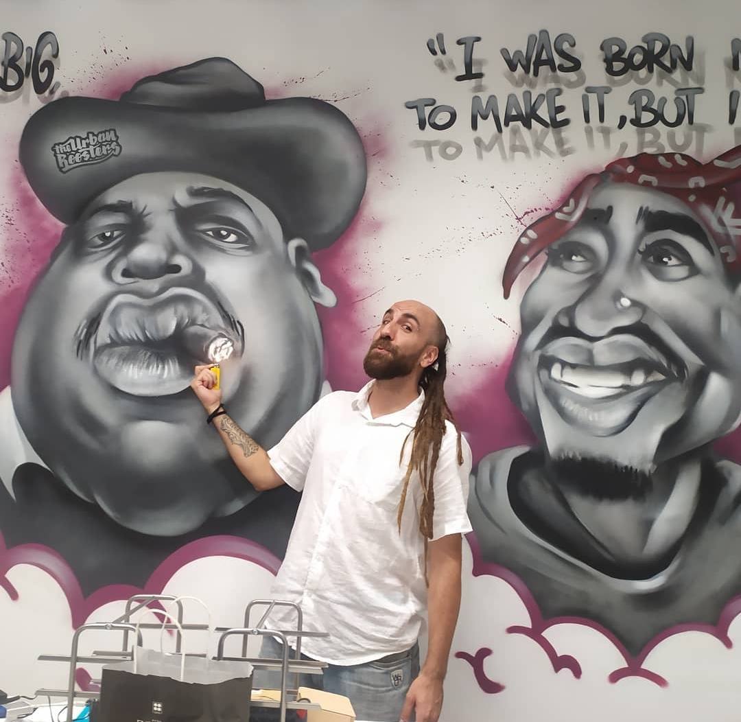 Uno de los artistas más buscados (y que firma buena parte de lo que puede verse en la ciudad) posa junto a Notorius Big y 2Pac en las oficinas de 'The Urban Roosters' (@chavolar_).