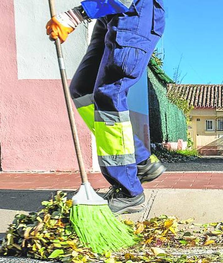 Imagen secundaria 2 - A la izquierda las puertas de las viviendas, este lunes, con nuevas cerraduras. A la derecha los servicios de limpieza frente al lugar de los hechos. 