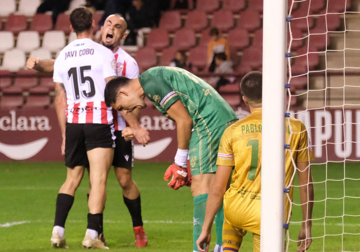 El portero del Calahorra lamenta un gol encajado mientras Cobo y Madrazo lo celebran.