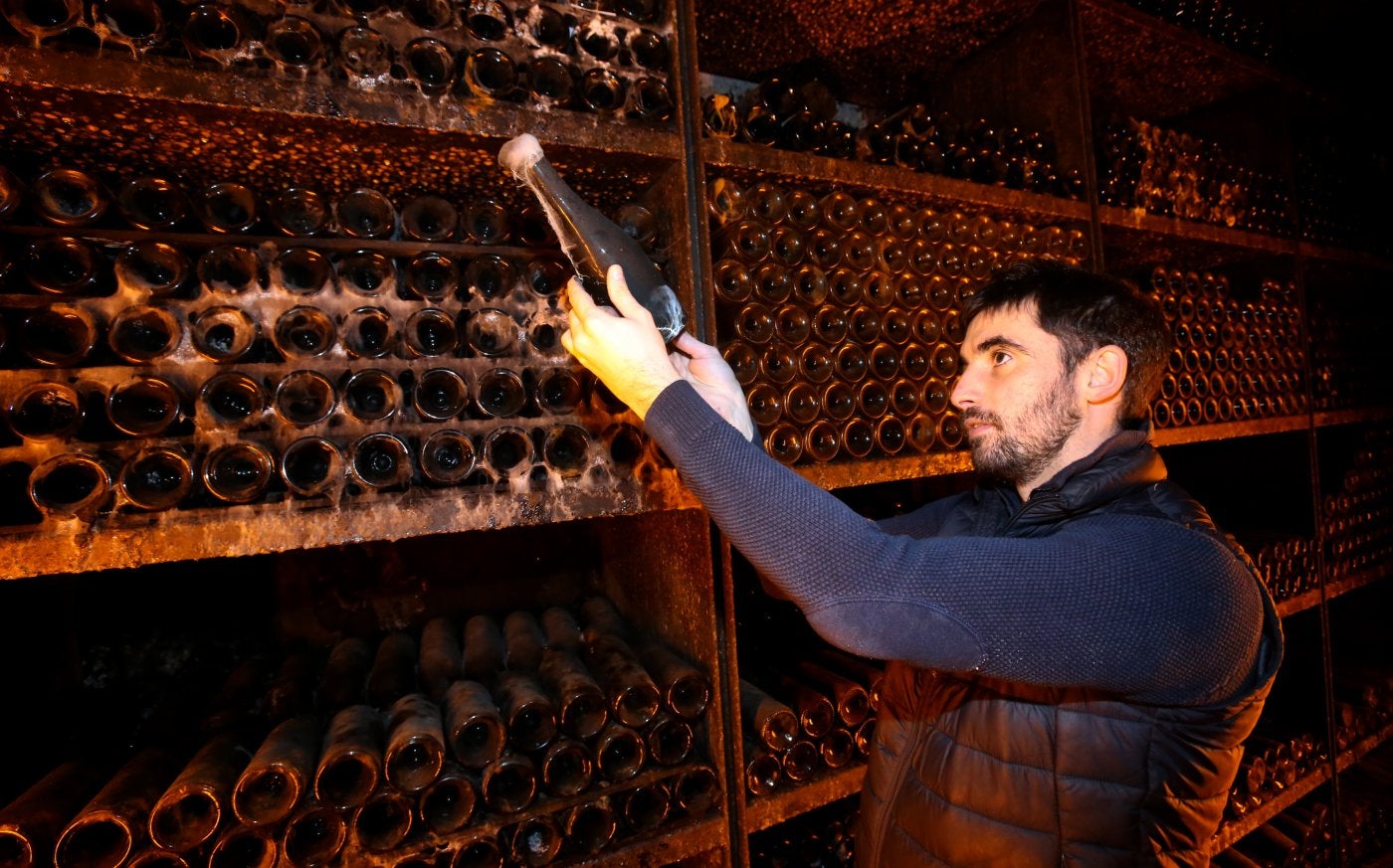 Eduardo Saracíbar, responsable de enoturismo de la bodega, observa uno de los vinos del botellero.