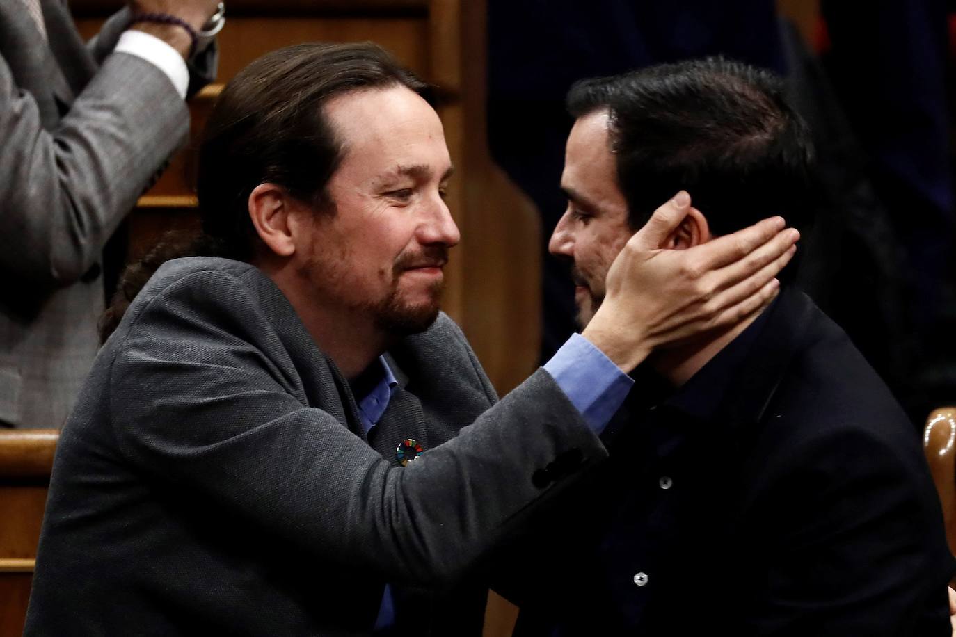 El líder de Unidas Podemos, Pablo Iglesias, se abraza con el líder de Izquierda Unida, Alberto Garzón, después de que el candidato socialista Pedro Sánchez lograra la confianza del Congreso para un nuevo mandato como presidente del Gobierno.