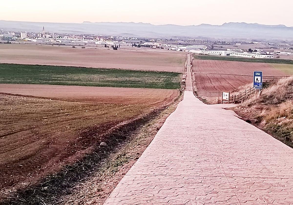 Tramo pavimentado del Camino de Santiago junto al área de descanso, a la derecha de la imagen.