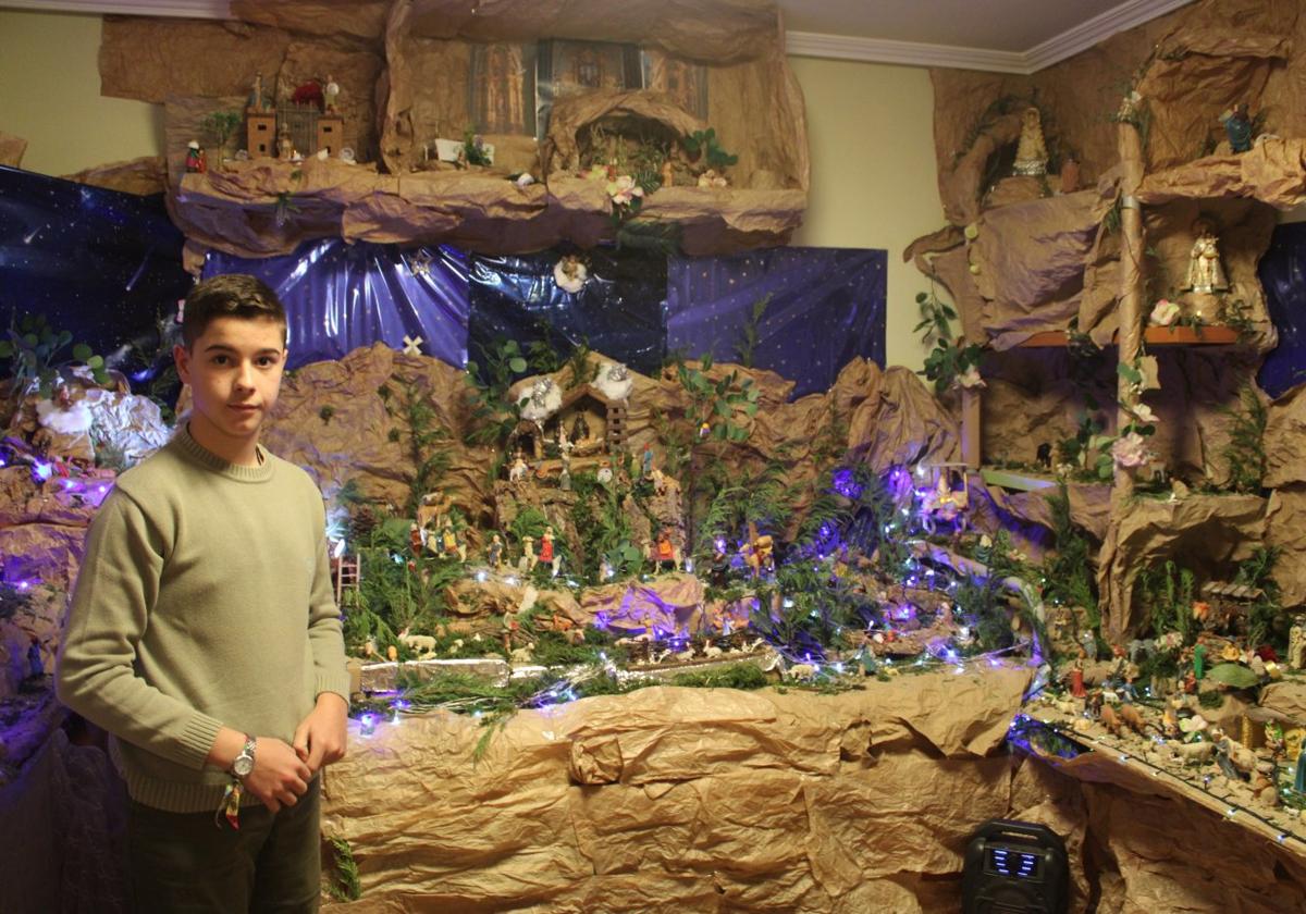 Víctor Rodríguez, najerino de 14 años, posa orgulloso frente a su gran belén, que este año ha alcanzado las 250 figuras.