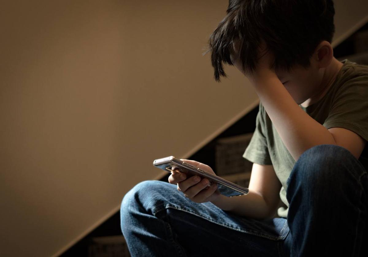 Un joven utiliza su teléfono móvil.