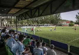 Vista del campo de fútbol desde la grada, con un torneode fútbol 8 en juego.