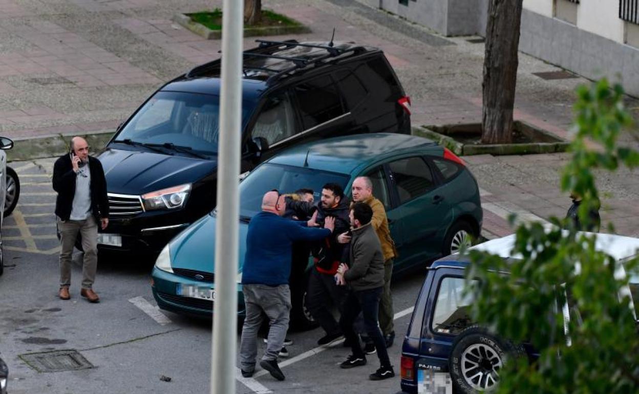 Varias personas sujetan a un hombre en el momento en el que dos agentes de Policía Nacional detienen al sospechoso del asesinato del niño de ocho años desaparecido en Ceuta.