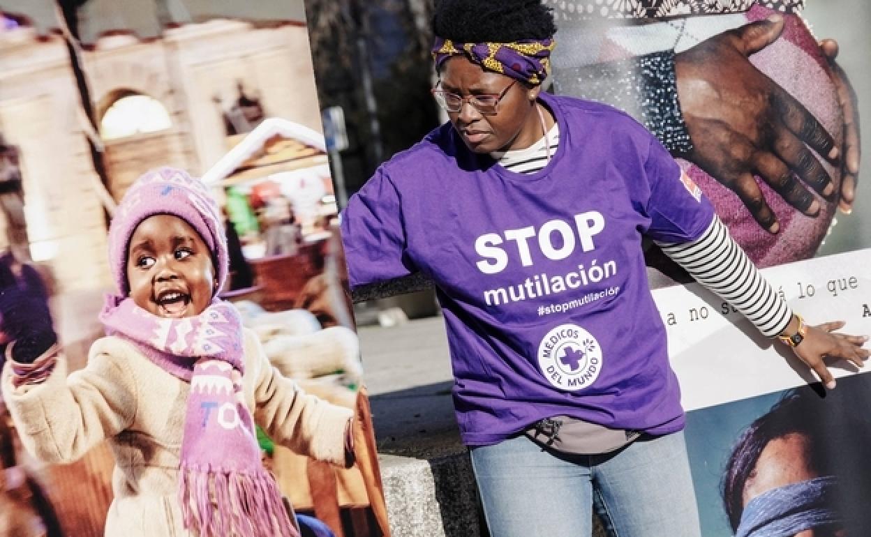 Una activista de MDM coloca fotografías contra la mutilación genital femenina