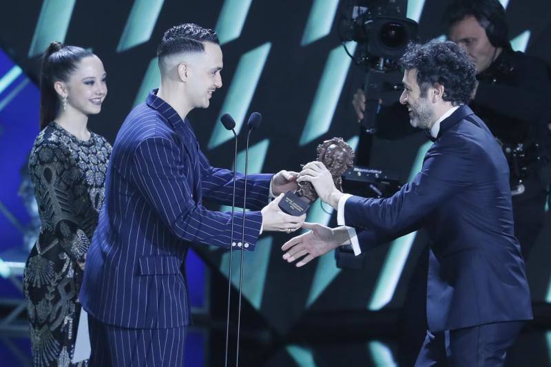 El realizador Rodrigo Sorogoyen (d) recibe de manos del cantante C. Tangana el premio a mejor fotografía en nombre del director de fotografía, Alex de Pablo, por su trabajo en 'As Bestas'. 