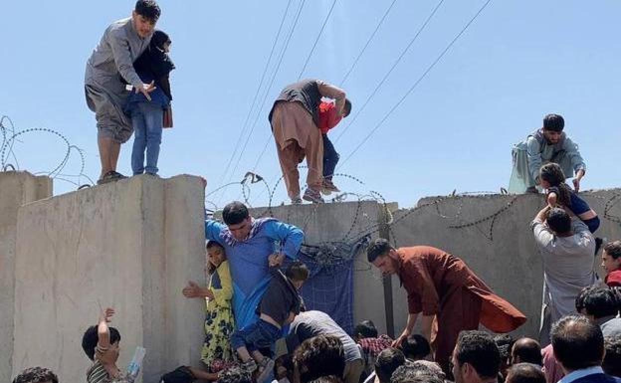 Afganos se agolpan a lo largo del muro del aeropuerto de Kabul para intentar huir del país en agosto de 2021.